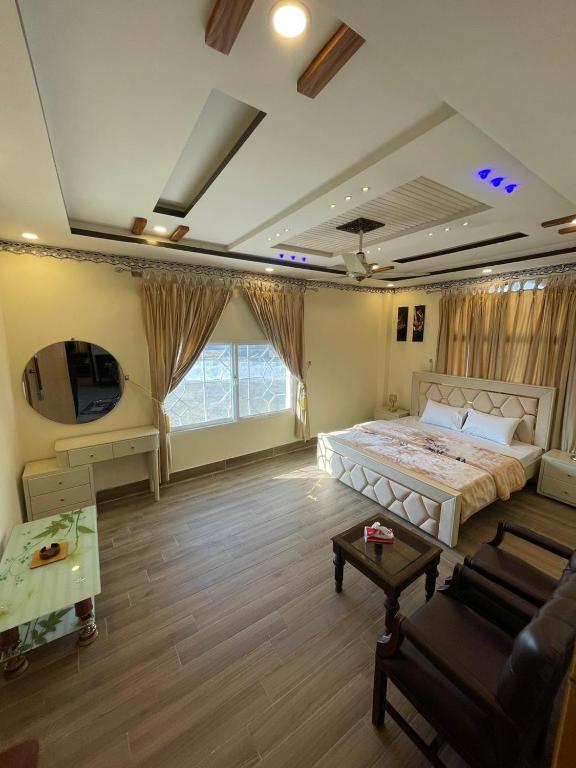 a large bedroom with a large bed and a couch at Royal swiss Hotel Khanpur in Khānpur