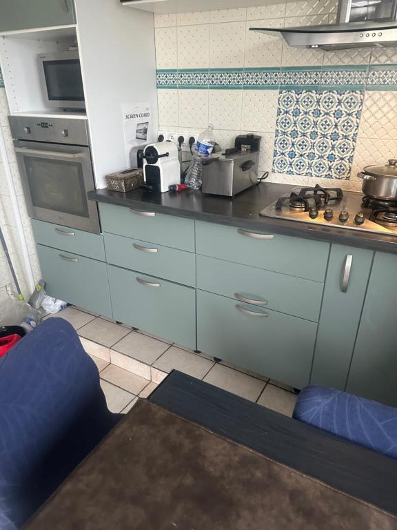 a kitchen with blue cabinets and a counter top at Laila in Creil