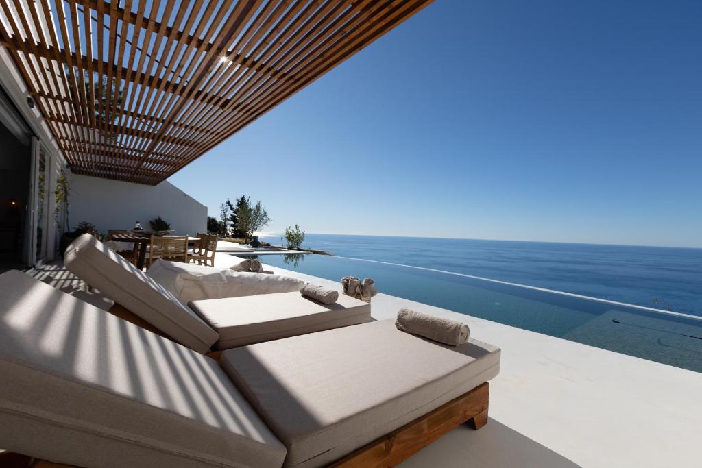 a balcony with chairs and a view of the ocean at Amore Luxury Villas Resort in Athani