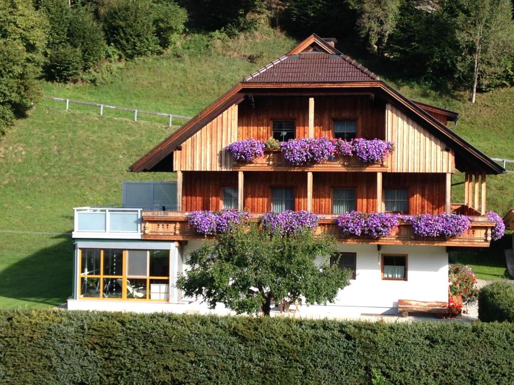 a house with purple flowers on the balcony at Simonbauerhof in Bad Kleinkirchheim