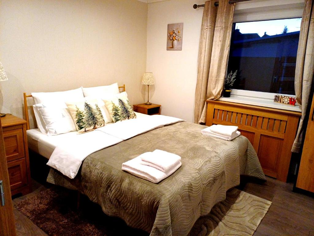 a bedroom with a large bed with towels on it at Ubytovanie Pod lesom in Ľubica
