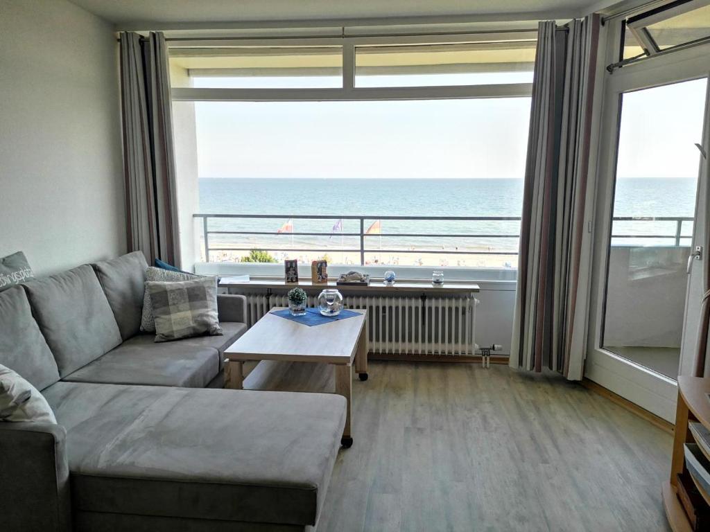 a living room with a couch and a view of the ocean at Strandhotel Wohnung 61 in Dahme
