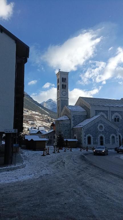 a large building with a clock tower in a town at Valdidentro sweet home in Valdidentro