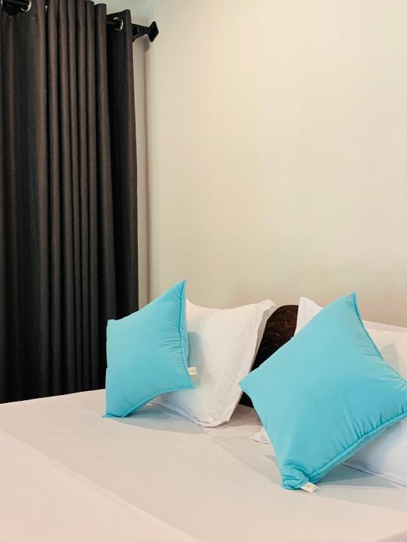 two blue pillows sitting on top of a bed at D2 Villa in Tangalle