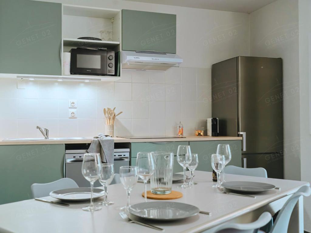 a kitchen with a table with wine glasses on it at Maison de vacances près du Mont Ventoux in Aubignan