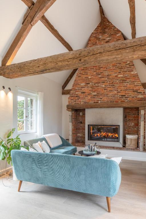 a living room with a blue couch and a fireplace at Boonackere Cottage in Oosterzele