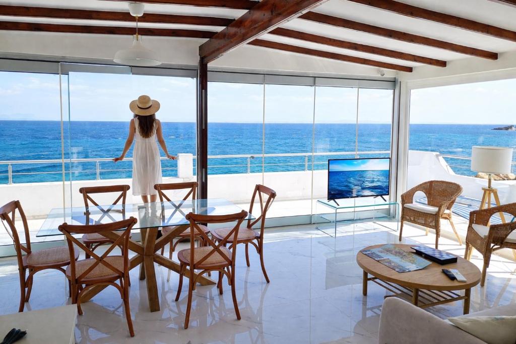 a woman standing in a living room looking out at the ocean at Luxury Seafront Panorama Penthouse in Chios