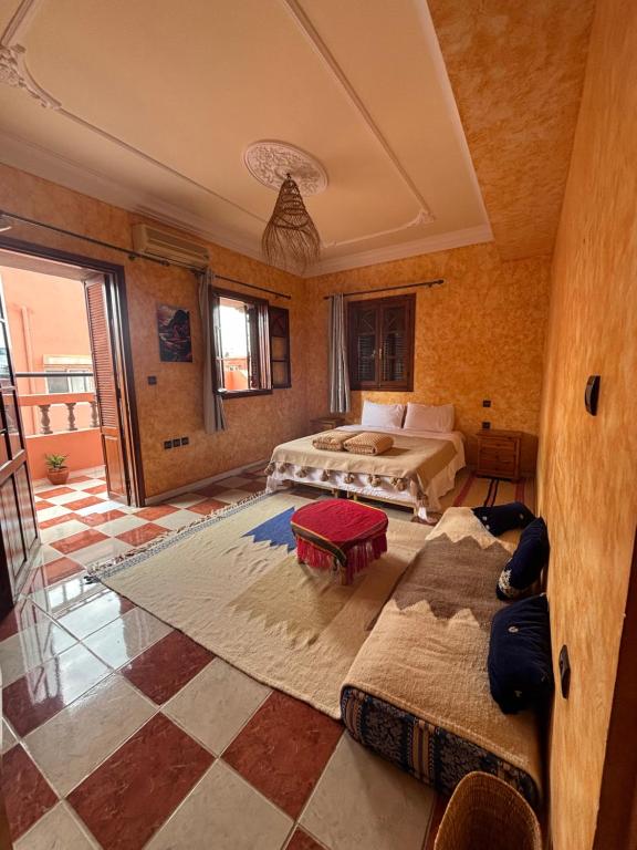 a bedroom with two beds and a table in it at Berber Waves Surf House in Tamraght Ouzdar