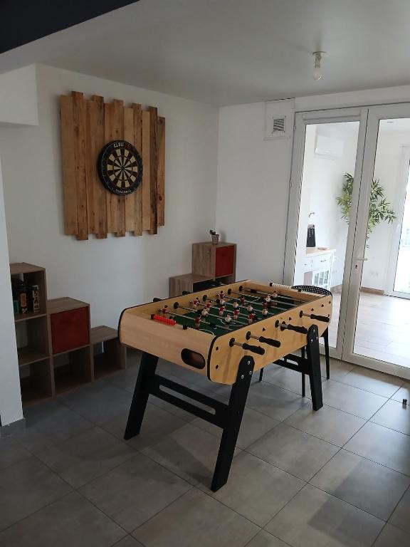 a large chessboard table in a room with a clock at l'auberge des trois lieux in Calais