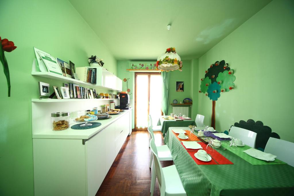 una cocina verde con mesa larga y sillas en B&B Francesco in Assisi en Asís