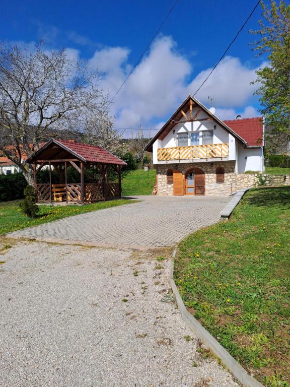 a house with a pavilion next to a driveway at Vadrózsa Nyaraló in Balatongyörök