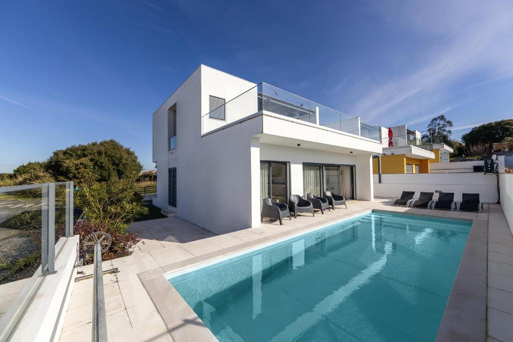 a swimming pool in front of a house at Silver Coast Haven in Coto