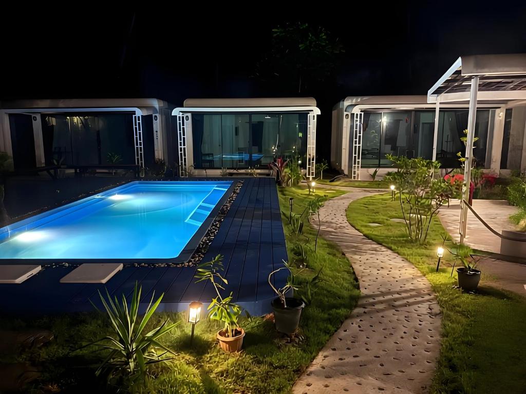 a swimming pool in front of a house at night at Samui Land Haven in Taling Ngam Beach
