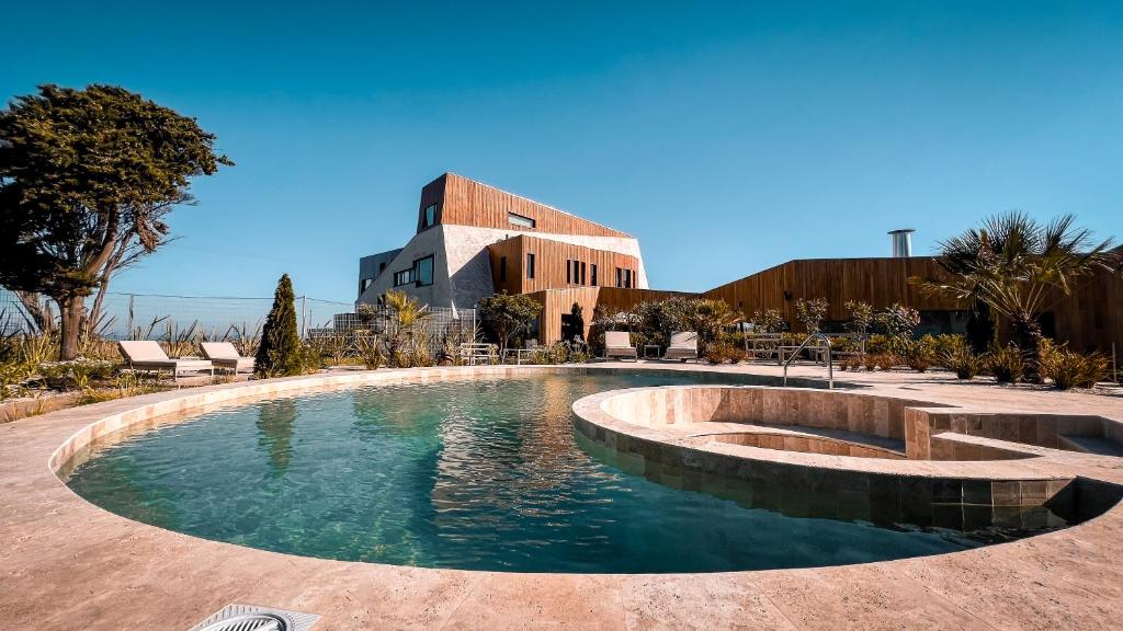 a swimming pool in front of a building at Locus Solus Hotel Singular in Mar del Plata