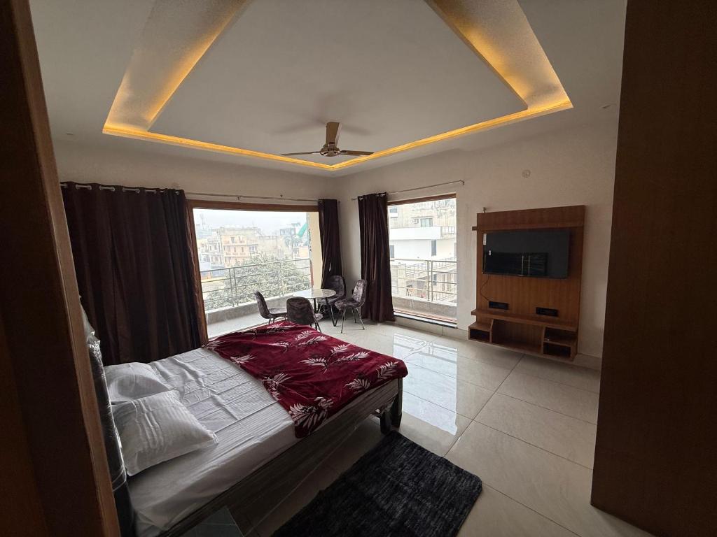 a bedroom with a bed and a large window at Zora apartment in Rohtak