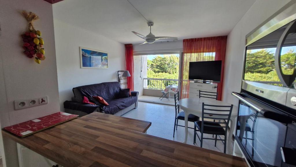 a living room with a couch and a table at O'Paloma - appartement T2 au port - Parking - Terrasse in Saint-Cyprien-Plage