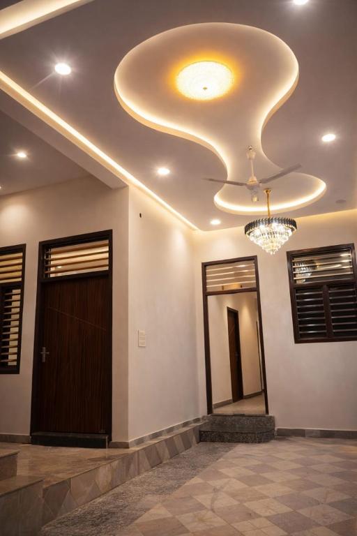 a room with a ceiling with a door and a chandelier at Vrindavaneshwari Residence in Vrindāvan