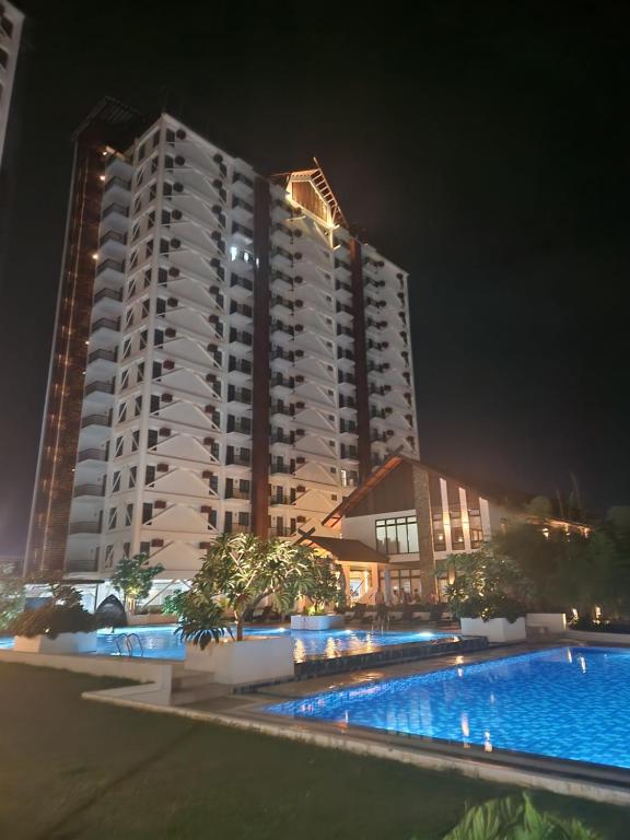 a large apartment building with a swimming pool at night at AJB Royal Ocean Crest Mactan Cebu in Cebu City
