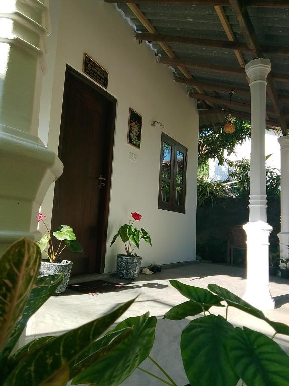eine Haustür mit Topfpflanzen in der Unterkunft Binu Home stay in Dikwella