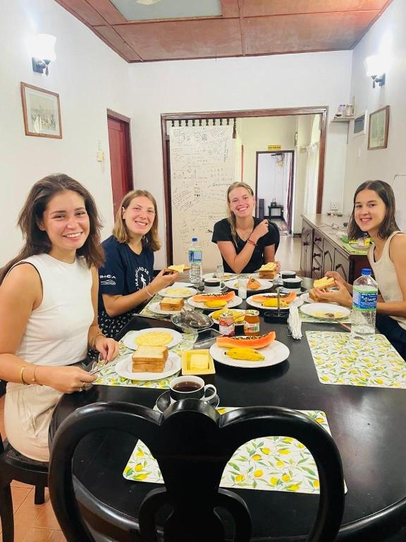 a group of women sitting around a table eating food at 2in1 Kandy Hostel in Kandy