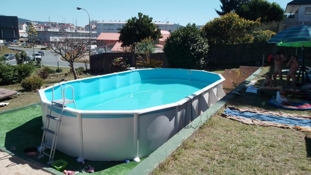 a large swimming pool in a yard with a large tub at A morada do peregrino in Poio