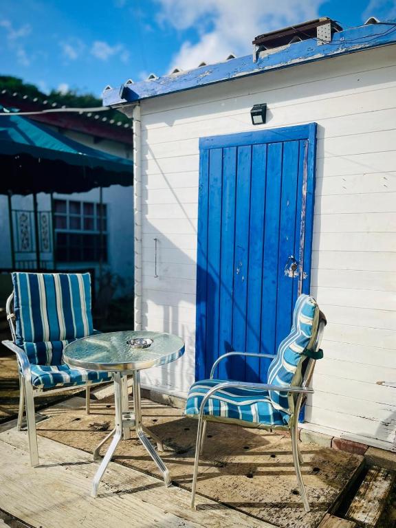 two chairs and a table and a blue door at Blue Moon Cabin in Willemstad