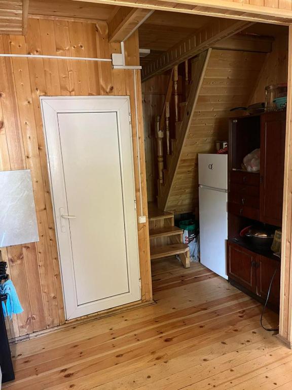 a door in a room with a refrigerator and stairs at Дом в Бахмаро in Chʼkhakoura