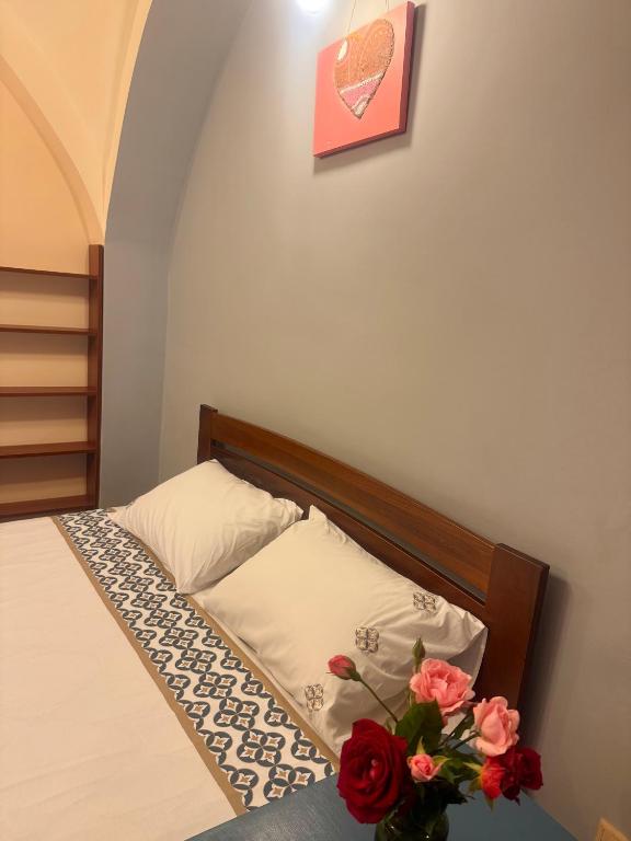 a bedroom with a bed with a vase of flowers at Срібний ключ in Mukacheve