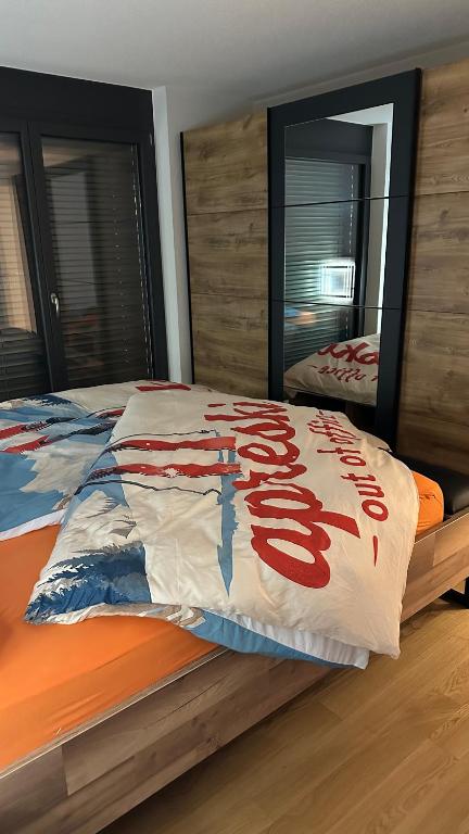 a bed with red writing on it in a bedroom at Bergperle in Grächen