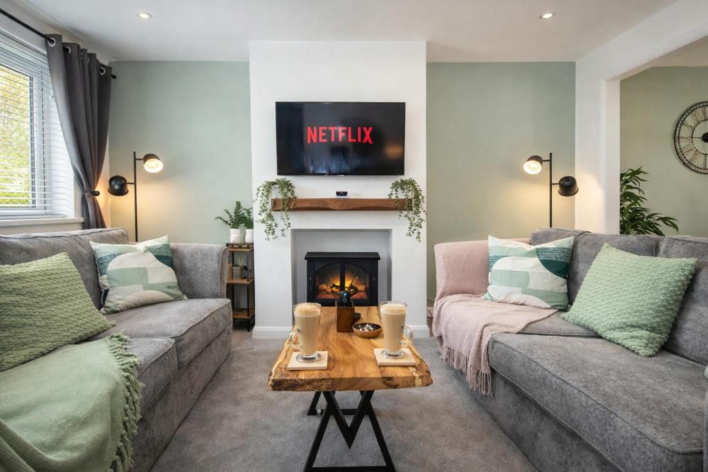 a living room with two couches and a fireplace at Stylish 4 Bed House, Free Parking, Close to M4 Newport in Newport
