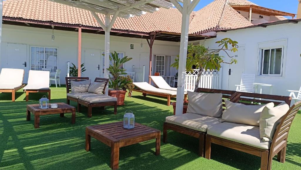 a patio with chairs and tables on a lawn at Villa las Flores in Adeje