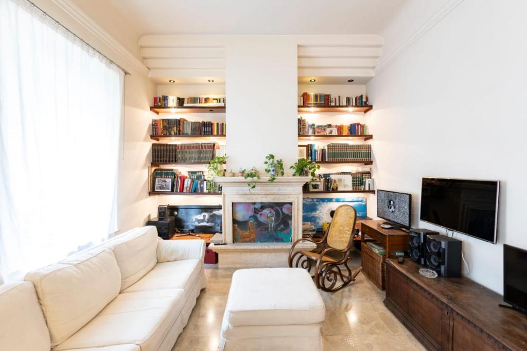 a living room with a white couch and a fireplace at Villa Olivieri 1928 in Ascoli Piceno