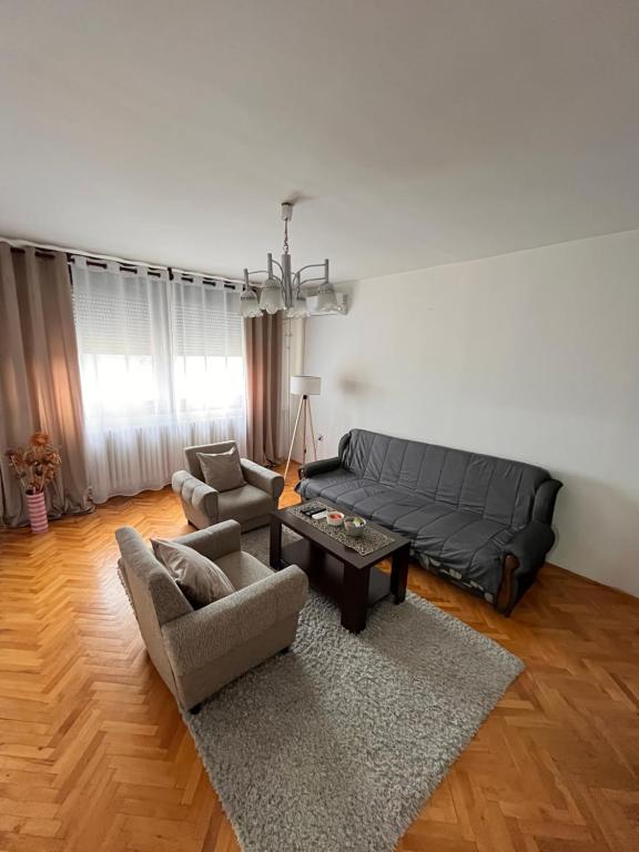 a living room with a black couch and a table at Devetka in Pirot