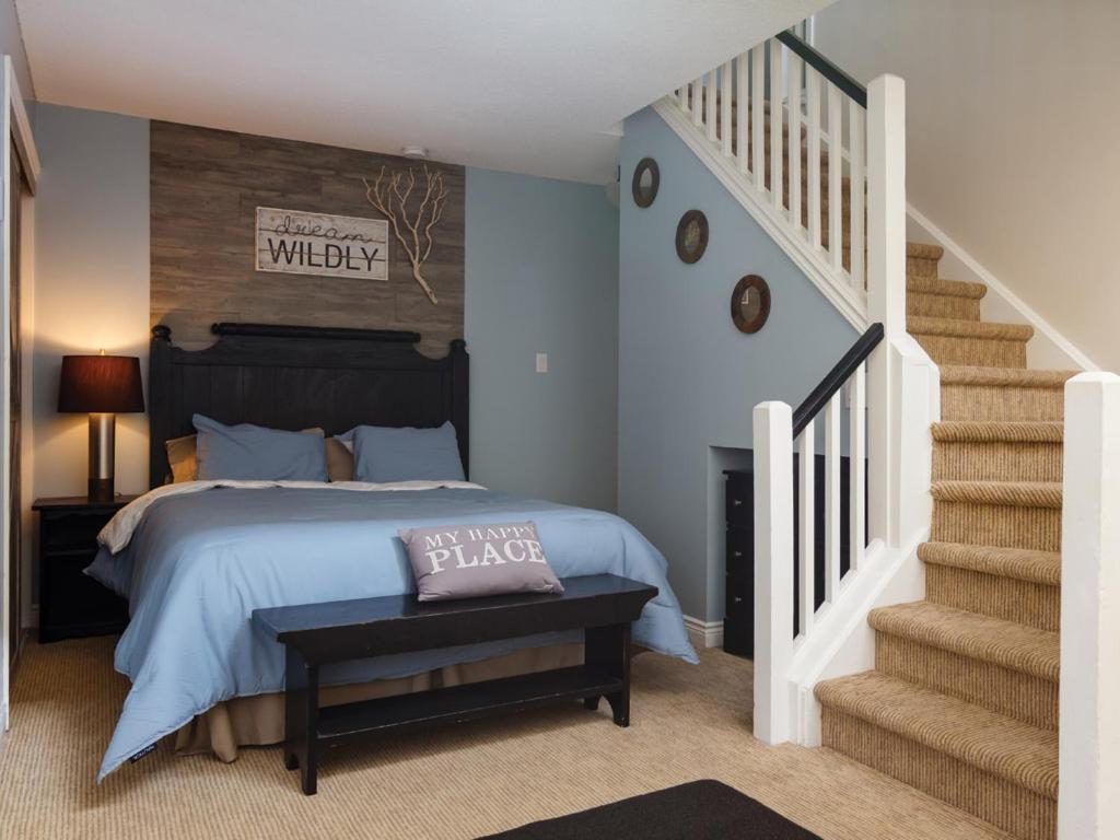 a bedroom with a bed and a staircase at Condo Loft at Blue Mountain in Blue Mountains