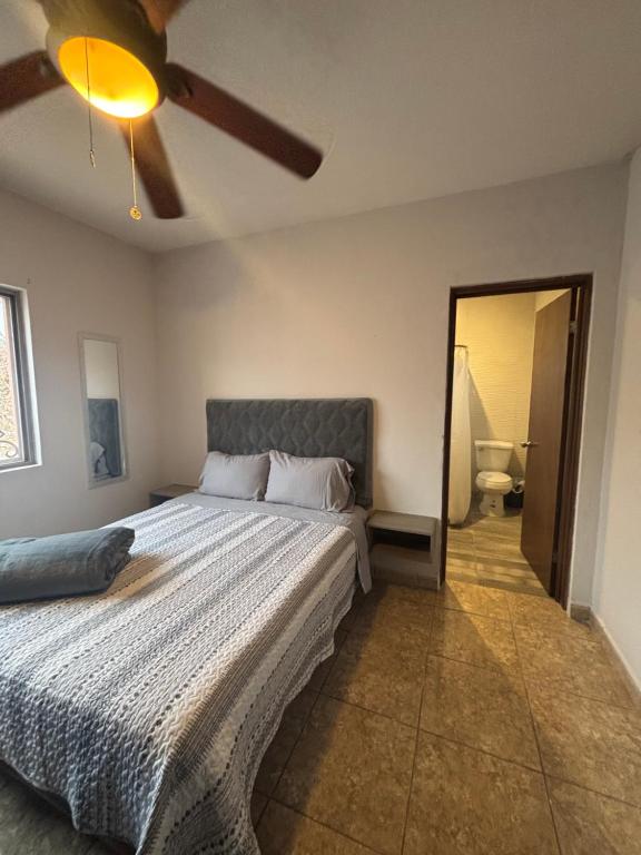 a bedroom with a bed and a ceiling fan at Habitacion Cedro in Saltillo
