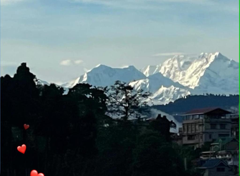 two hearts are flying in front of a snow covered mountain at Sungava homestay in Mirik