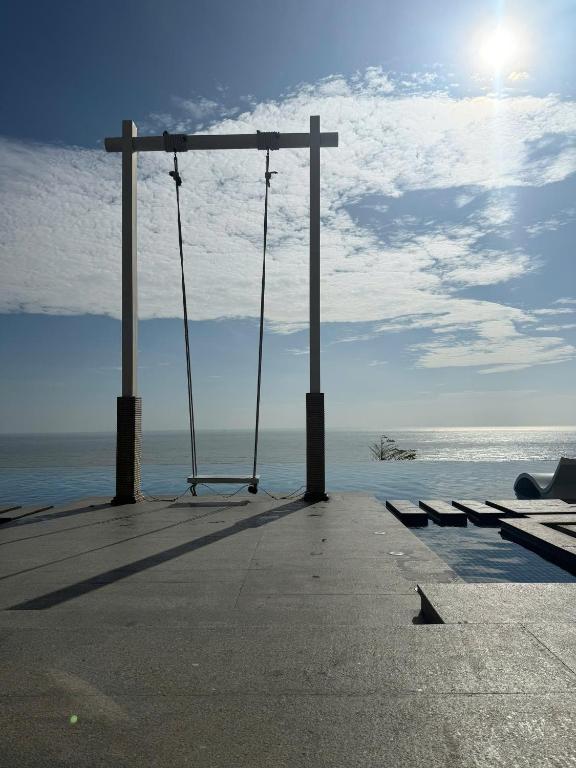 a swing on the beach with the ocean in the background at Apec Mandala Chambay - Dimond Hotel in Ấp Thiẹn Ái