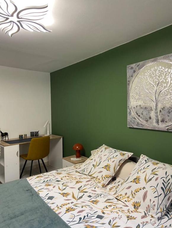 a bedroom with a bed with a green wall at Meuble maison vigneronne in Saint-André-de-Sangonis