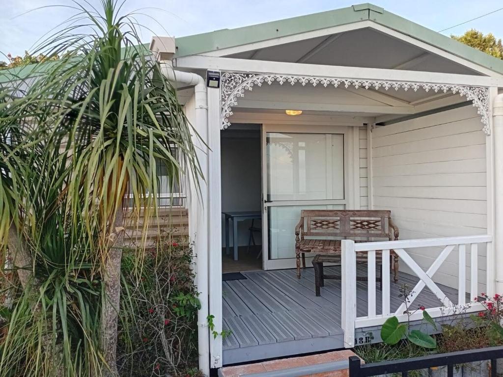 a porch with a white pergola and a table at Bungalow & Jacuzzi 24h24 7j7 in Petite Île