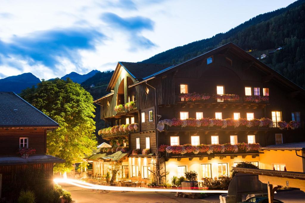 ein Gebäude in den Bergen mit eingeschaltetem Licht in der Unterkunft Hotel Mölltalerhof in Rangersdorf