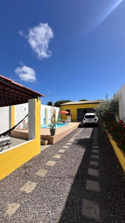 a house with a car parked next to a driveway at Casa Lagoa & Praia in Estância