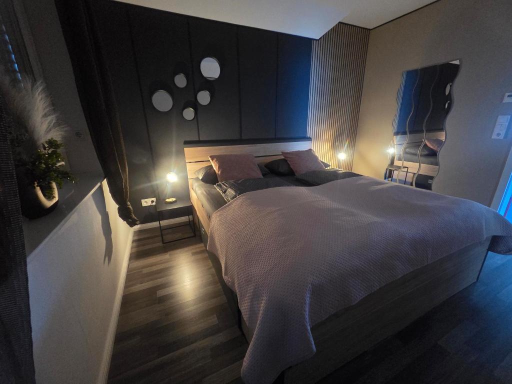 a bedroom with a large bed in a room with lights at Haus Moor Merland in Moormerland