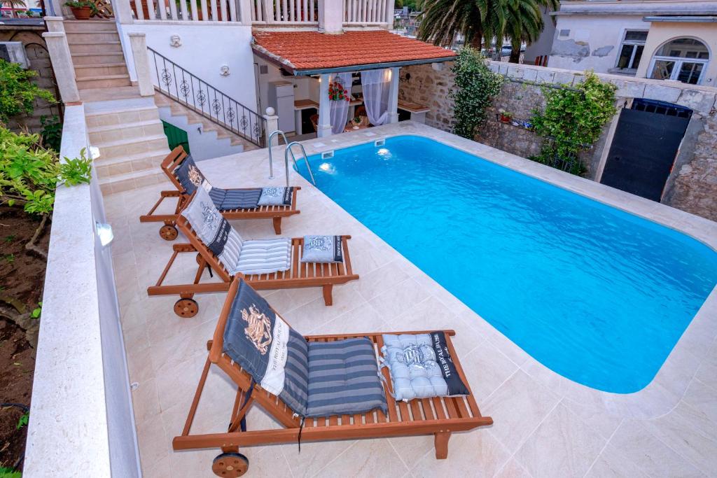 an overhead view of a swimming pool with chairs and a house at Villa Radovani Jelsa Hvar in Jelsa