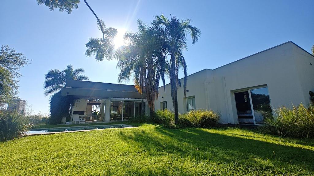 a white building with palm trees in front of it at Casa Azahares in Yerba Buena