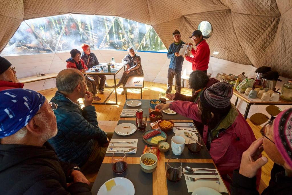 a group of people sitting around a table in a tent at Fitz Roy Comfort Camp - El Chaltén in El Chalten
