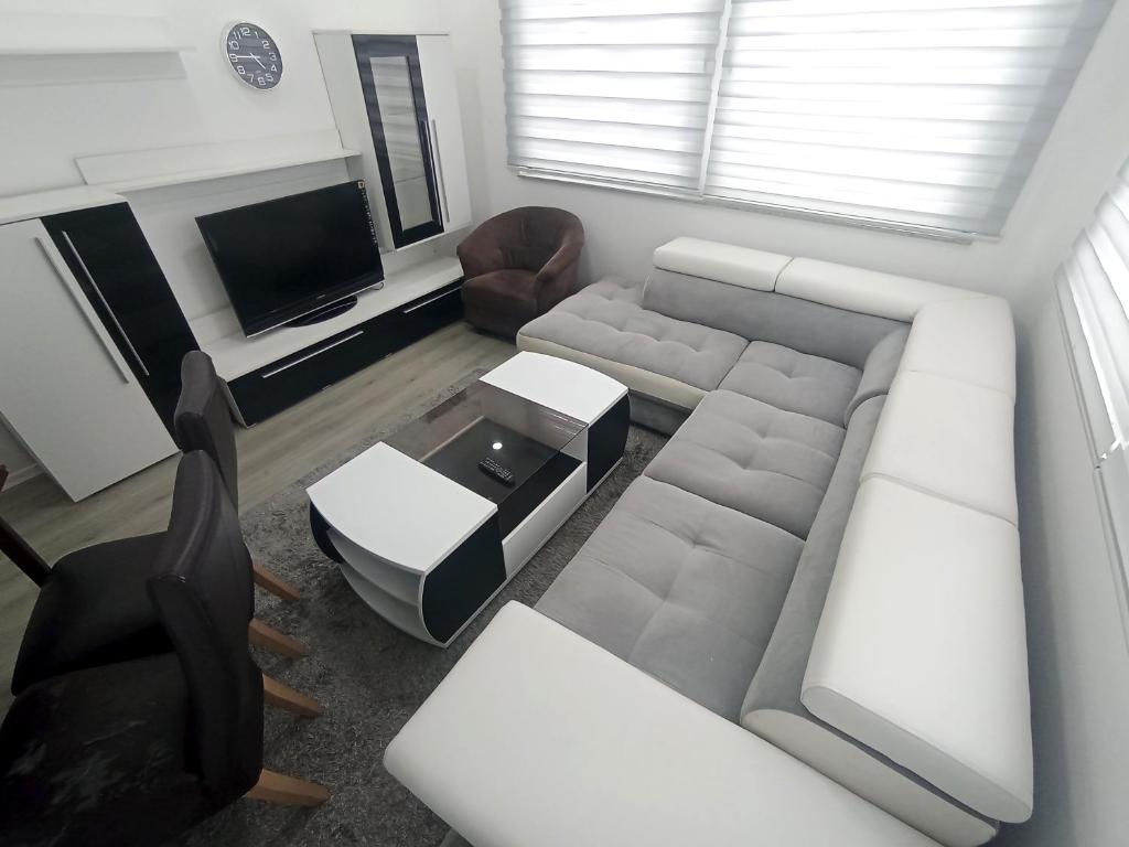 a living room with a couch and a tv at Apartman Alić in Vogošća