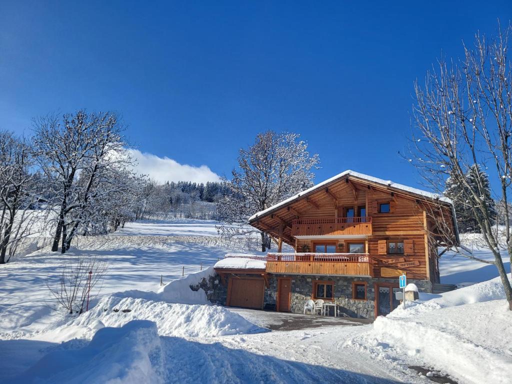 a log cabin in the snow with snow at Appartement cosy face aux Aravis in Le Grand-Bornand