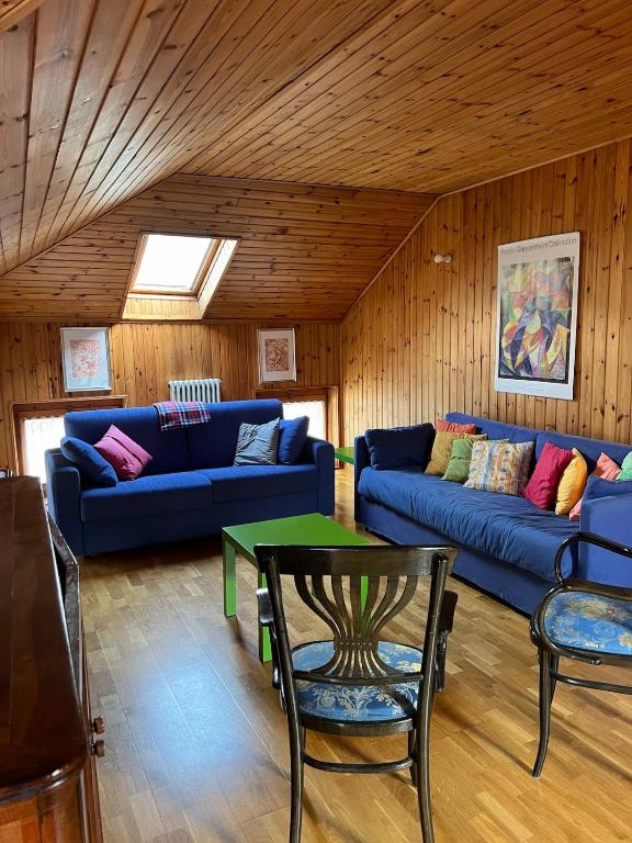 a living room with a blue couch and a table at La Mansarda di Tiziano in Pieve di Cadore
