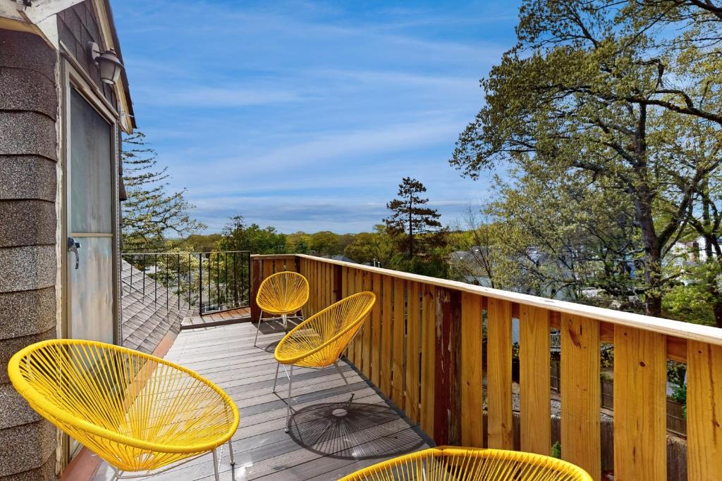 a deck with yellow chairs and tables on it at 3 Mi to Franklin Park Zoo! Bright Residential Stay in Boston
