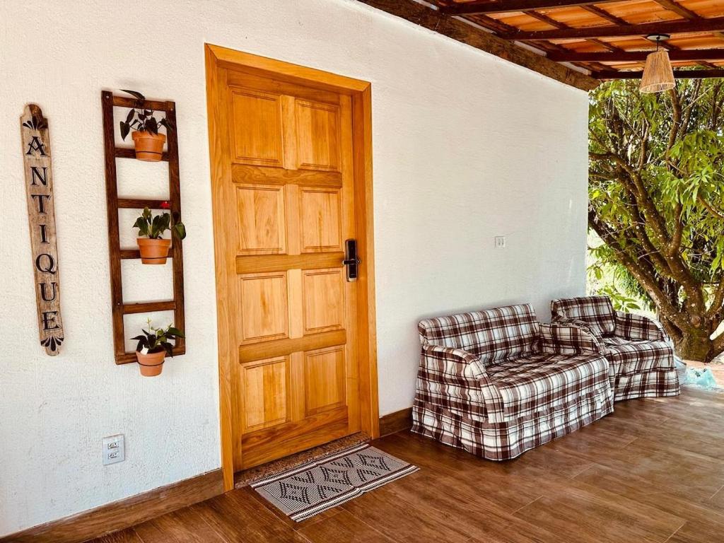a room with a wooden door and a couch at Casinha da Serra in Rio Acima